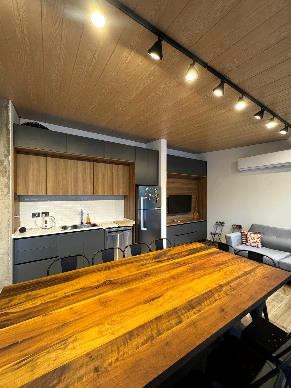Cocina y comedor integrados con cielorraso de madera